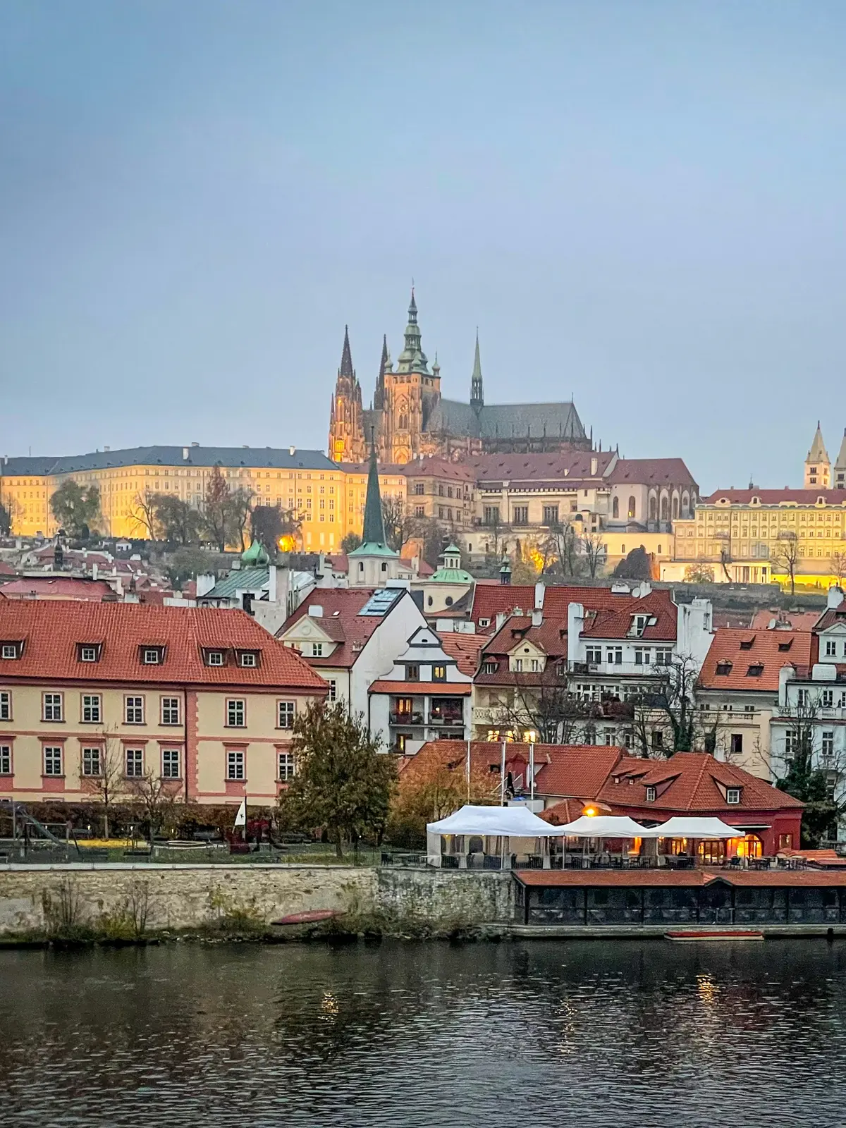 Le château de Prague et Malá Strana vus depuis la Vltava, au crépuscule.